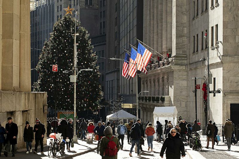 People walk past  the New York Stock Exchange on Tuesday. Stock prices dropped across  the board Tuesday after President Donald Trump indicated he’d be willing to wait another year before striking a trade agreement with China and threatened levies on France, Brazil and Argentina.   
