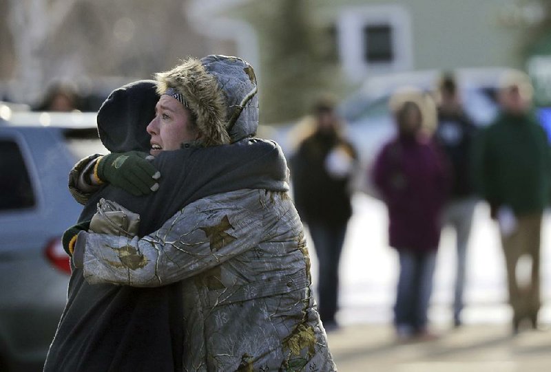 Sarah Rogstad hugs her son, Morgan, after being reunited in the wake of Tuesday’s school shooting in Oshkosh, Wis. More photos are available at arkansasonline.com/124school/ 