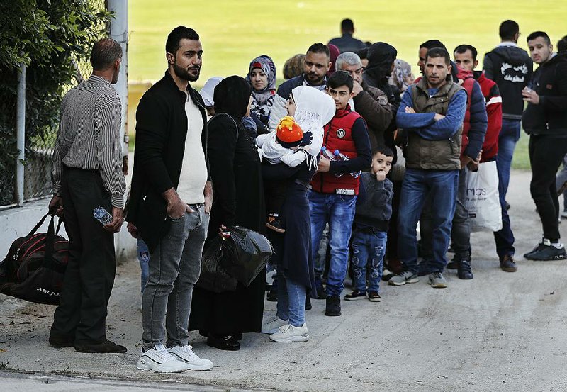 Syrian refugees in Beirut wait to board a bus Tuesday to take them home to Syria. 