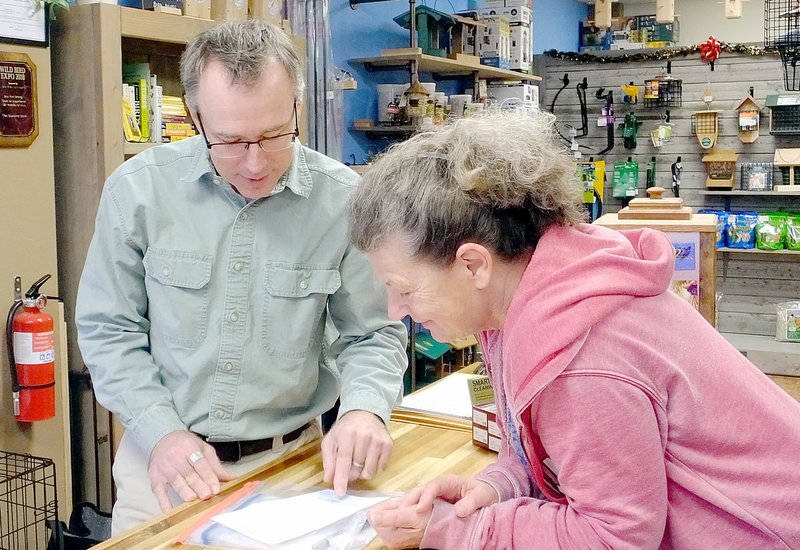 Lynn Atkins/The Weekly Vista Butch Tetzlaff, owner of the Bluebird Shed, shows volunteer Linda Oliphant the materials she would need to help research bluebirds this winter.