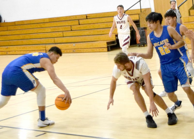 Westside Eagle Observer/MIKE ECKELS After stealing the ball away from a Wolves player, Edgar Herrera (left) stops for a second to gain control of the ball before passing it off to a teammate during the first quarter of the Lincoln vs. Decatur basketball contest at the old middle school gym in Lincoln Nov. 26.