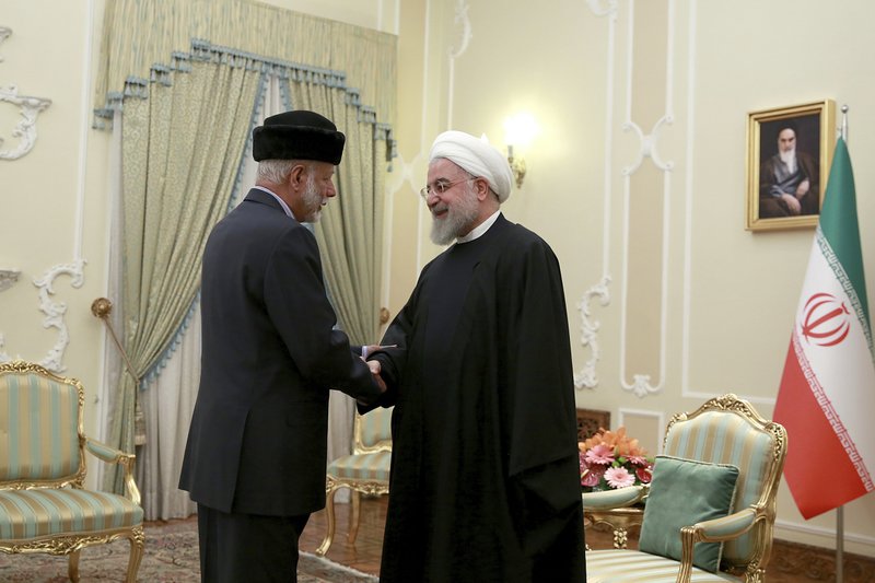 In this photo released by the official website of the office of the Iranian Presidency, President Hassan Rouhani, right, shakes hands with Omani Minister of State for Foreign Affairs Yusuf bin Alawi at the start of their meeting, in Tehran, Iran, Tuesday, Dec. 3, 2019 (Office of the Iranian Presidency via AP)