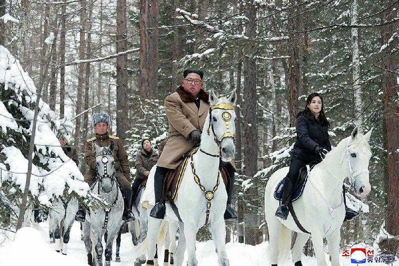 North Korean leader Kim Jong Un, with his wife, Ri Sol-ju, at his side Wednesday, rides a white horse up the sacred Mount Paektu. Meanwhile, Kim’s military chief issued a statement berating President Donald Trump for suggesting U.S. military force against North Korea could be an option if nuclear talks fail. More photos at arkansasonline.com/125kim/ 