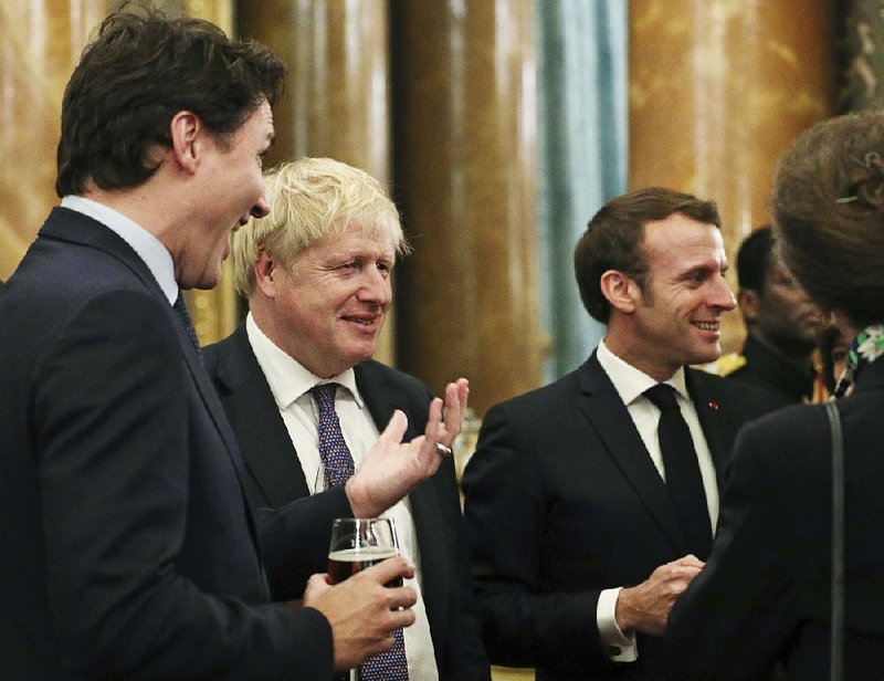 Canadian Prime Minister Justin Trudeau (from left), British Prime Minister Boris Johnson and French President Emmanuel Macron gather at Tuesday’s NATO reception at Buckingham Palace in London. Trudeau was overheard gossiping about President Donald Trump during the event, prompting Trump to fire back, calling the Canadian leader “two-faced.” 