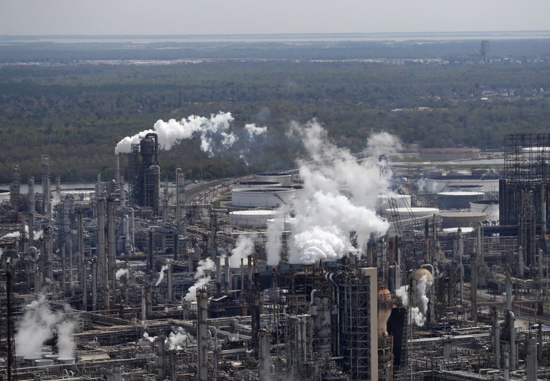 In this March 8, 2018, file photo wetlands are seen beyond the Shell Norco refinery in Norco, La. The world may be heading into an oversupply of oil, and that possibility is hanging over members of the OPEC cartel, which will meet later this week to decide whether to further cut production to boost prices. (AP Photo/Gerald Herbert, File)