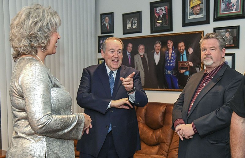 From left, Susan Wilkins speaks with former Arkansas Gov. Mike Huckabee, center, and incumbent state Sen. Alan Clark, R-District 13, ahead of a campaign fundraising event for Clark at The Vapors on Wednesday. - Photo by Grace Brown of The Sentinel-Record