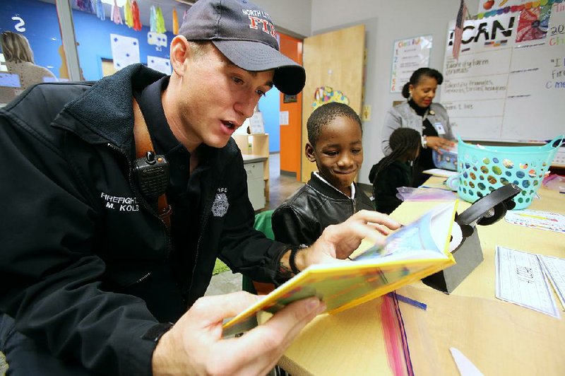 North Little Rock firefighter Matthew Kolb reads the book I Like Me to Reco Reed, 5, in Jana Thomas’ kindergarten class Thursday at Amboy Elementary School in North Little Rock. About 670 of the personalized books were given away to kindergarten students in North Little Rock school district by the North Little Rock Rotary Club. More photos at arkansasonline.com/126nlrbooks/.