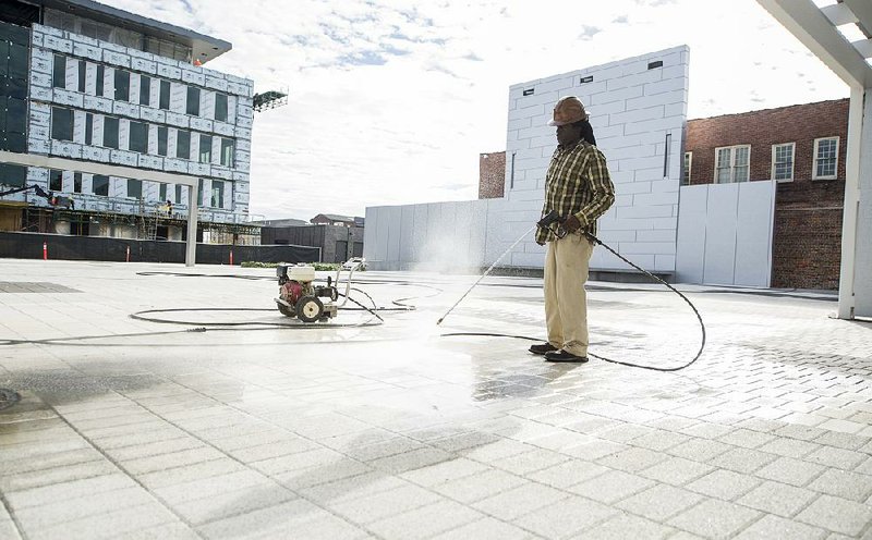 FILE — Michael Green pressure washes a part of Argenta Plaza in North Little Rock on Dec. 5.