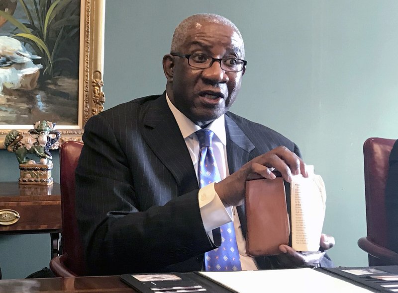 FILE - In this Aug. 17, 2018, file photo, Pulaski County Circuit Judge Wendell Griffen holds a copy of the U.S. Constitution at a news conference in Little Rock, Ark. The Arkansas Supreme Court on Thursday, Dec. 5, 2019, rejected the state attorney general's request to prohibit a judge who demonstrated against the death penalty from handling any cases involving her office. In a 4-3 decision, justices rejected the request by Attorney General Leslie Rutledge to remove the cases from Pulaski County Circuit Judge Wendell Griffen's court. (AP Photo/Andrew DeMillo, File)