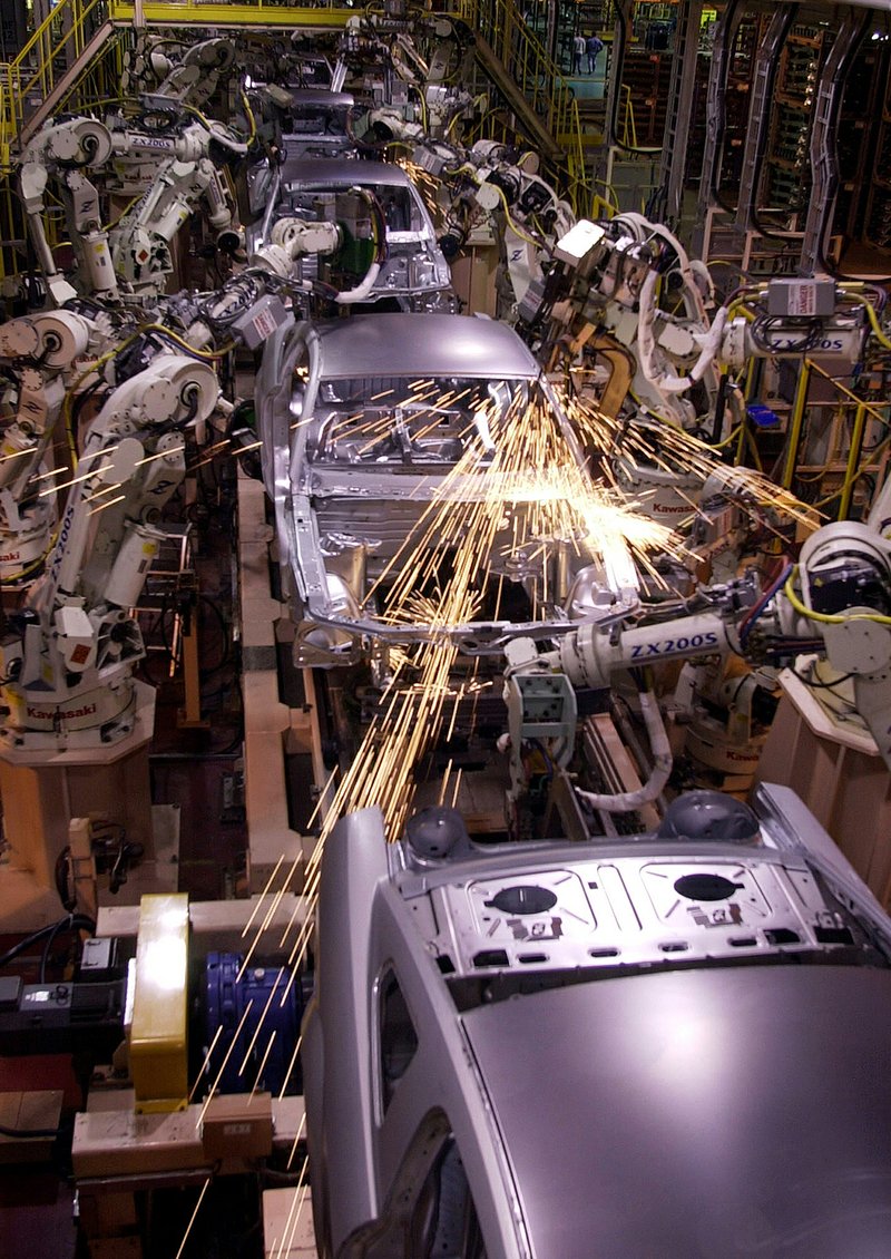 Welding robots work on Ford Mustangs at the AutoAlliance International plant in Flat Rock, Mich., in 2005. The fine print in a revised North American trade deal requires that 70% of aluminum and steel used in vehicle production come from the continent. 