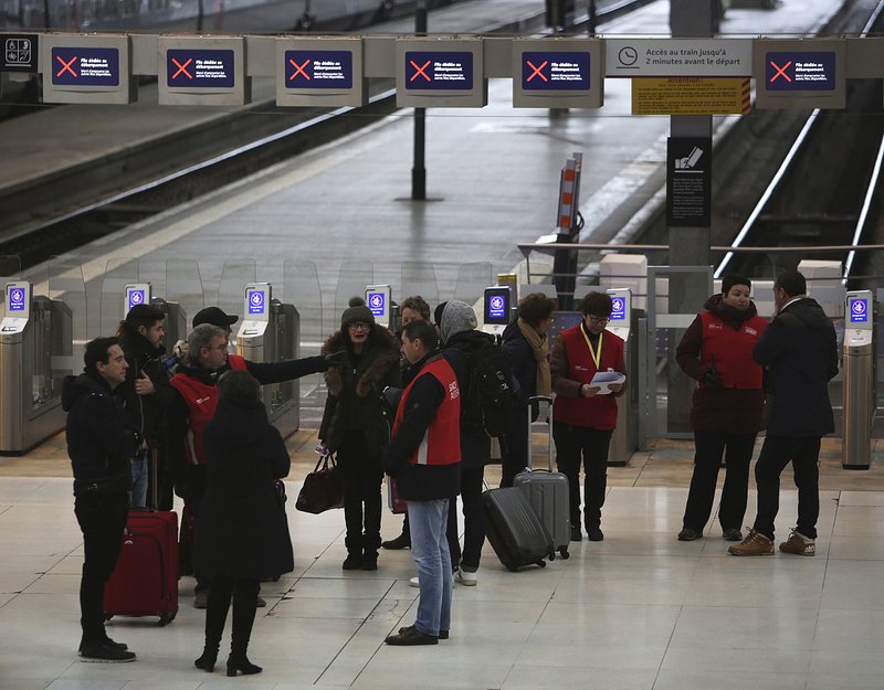 Railway employees (wearing red vests) give information to travelers Friday at the Gare de Lyon train station in Paris. More photos are available at arkansasonline.com/127travelers/ 