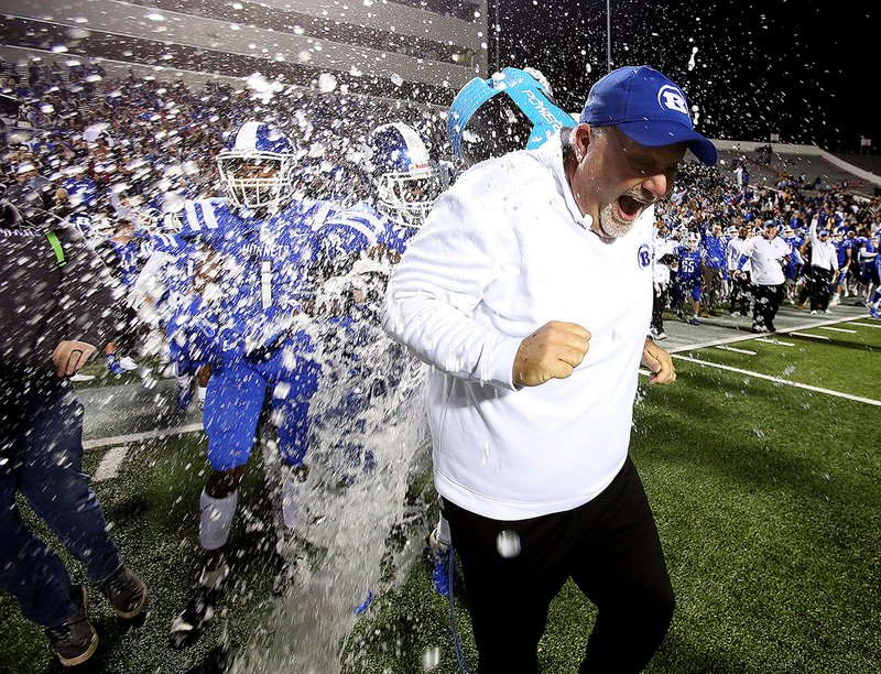 Bryant Coach Buck James is doused with ice water by players Kaleb Knox and Catrell Wallace after the Hornets won their second consecutive Class 7A state championship with a victory over North Little Rock on Friday night at War Memorial Stadium in Little Rock. More photos are available at arkansasonline.com/127nlrbryant.
