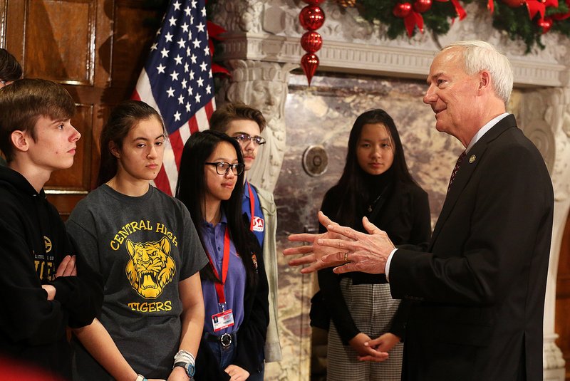 Arkansas Gov. Asa Hutchinson talks with high school students about the state’s interest in computer science after a news conference announcing a new computer science and cybersecurity task force Friday at the Capitol. 