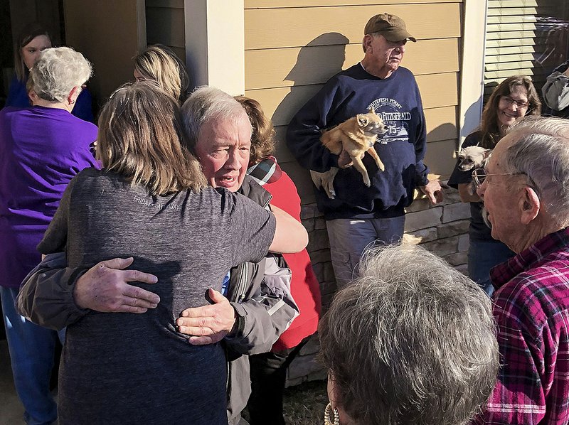 Dr. Les Anderson is met by a crowd of supporters and patients as he walks out of his clinic Friday in Lonoke. 
