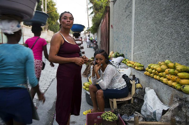 Wadlande Pierre (right) helps her mother, Vanlancia Julien, at their fruit and vegetable stand in the Delmas neighborhood of Port-au-Prince, Haiti. Julien said she lost a couple hundred dollars’ worth of produce because of recent protests that prevented her from selling on the street. 