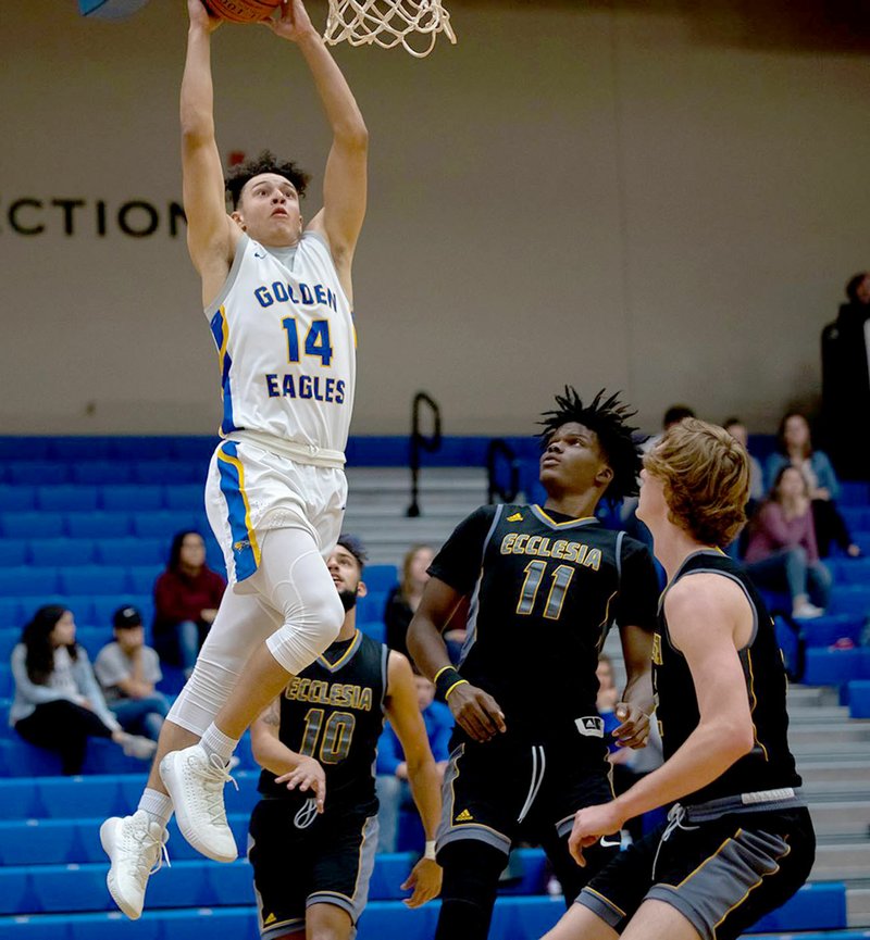 Photo courtesy of JBU Sports Information John Brown freshman James Beckom goes in for a dunk Tuesday in the Golden Eagles' 100-58 victory over Ecclesia at Bill George Arena.