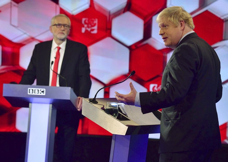 Opposition Labour Party leader Jeremy Corbyn, left, and Britain's Prime Minister Boris Johnson, during a head to head live Election Debate at the BBC TV studios in Maidstone, England, Friday Dec. 6, 2019. Britain's Brexit is one of the main issues for political parties and for voters, as the UK prepares for a General Election on Dec. 12. The debate is moderated by TV presenter Nick Robinson, right. ( Jeff Overs/BBC via AP)