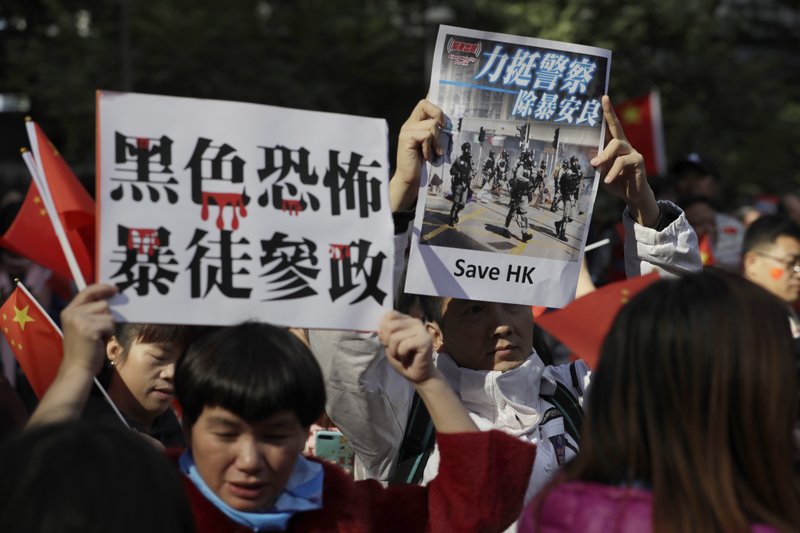 Pro-Beijing supporters hold up signs which reads &quot;Black Terror, Rioters involved in politics&quot; and &quot;Support Police, Get rid of Violence&quot; during a rally in Hong Kong on Saturday, Dec. 7, 2019. Six months of unrest have tipped Hong Kong's already weak economy into recession. (AP Photo/Mark Schiefelbein)