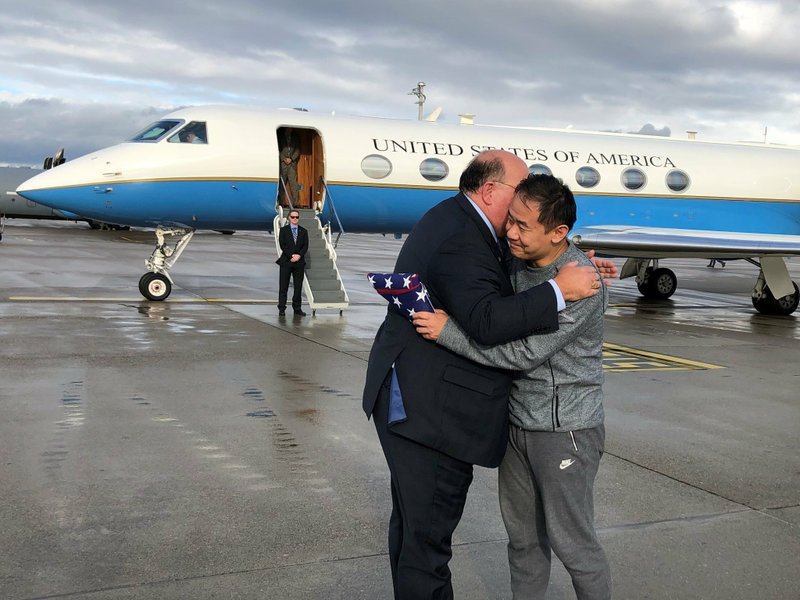 Chinese-American graduate student Xiyue Wang (right) is greeted Saturday in Zurich by Edward McMullen, U.S. ambassador to Switzerland and Liechtenstein, after Wang’s release by Iran. 
