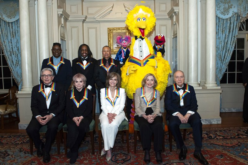 Front row from left, 2019 Kennedy Center Honorees Michael Tilson Thomas, Linda Ronstadt, Sally Field, Joan Ganz Cooney, and Lloyd Morrisett, back row from left, Philip Bailey, Verdine White, Ralph Johnson, and characters from "Sesame Street," Abby Cadabby, Big Bird, and Elmo pose for a group photo following the Kennedy Center Honors State Department Dinner at the State Department on Saturday, Dec. 7, 2019, in Washington. 