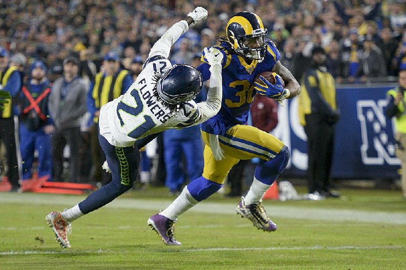 Los Angeles Rams running back Todd Gurley (right) scores past Seattle Seahawks cornerback Tre Flowers during the second half Sunday in Los Angeles. The Rams won 28-12. 