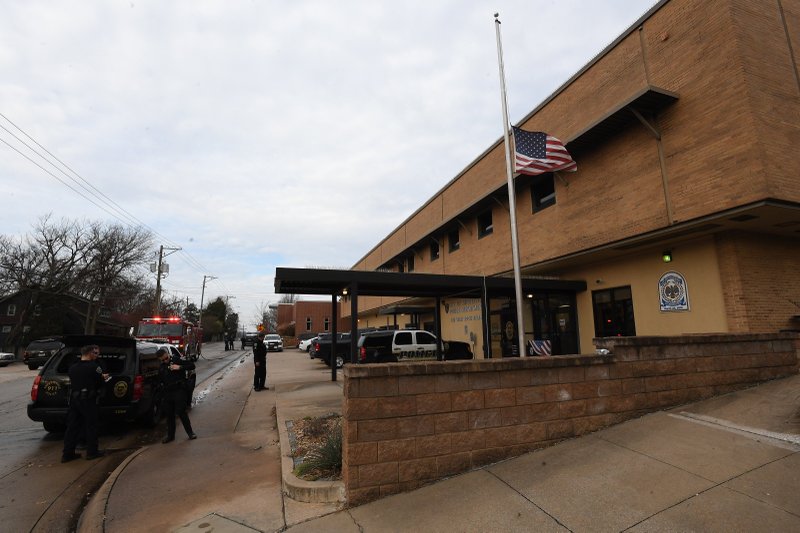NWA Democrat-Gazette/J.T. WAMPLER Fayetteville police gather outside of the police station Sunday Dec. 8, 2019 while the flag flies at half-mast after the Saturday night shooting death of police officer Stephen Carr behind the station in downtown. The suspected shooter, London T. Phillips, 35, of Fayetteville was killed at the scene by other officers.