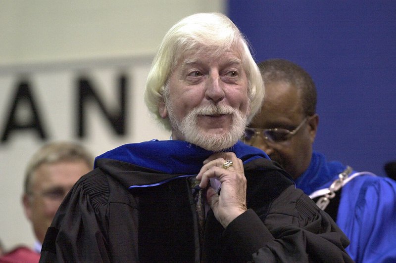 FILE - In a May 21, 2000 file photo, Carroll Spinney, center, best known for his TV character &quot;Big Bird&quot; from Sesame Street, receives an honorary doctor of Humane Letters degree from Eastern Connecticut State University President David G. Carter, right, during commencement in Willimantic, Conn. Spinney, who gave Big Bird his warmth and Oscar the Grouch his growl for nearly 50 years on &#x201c;Sesame Street,&#x201d; died Sunday, Dec. 8, 2019 at his home in Connecticut, according to the Sesame Workshop. He was 85. (AP Photo/Steve Miller, File)