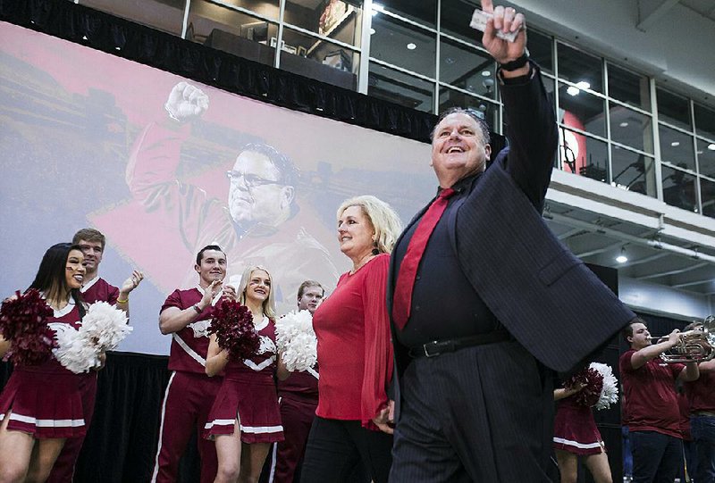 NWA Democrat-Gazette/CHARLIE KAIJO Coach Sam Pittman walks out to a greeting of cheering fans with his wife Jamie Pittman, Monday, December 9, 2019 during an introductory press conference at the Walker Pavilion in Fayetteville.

