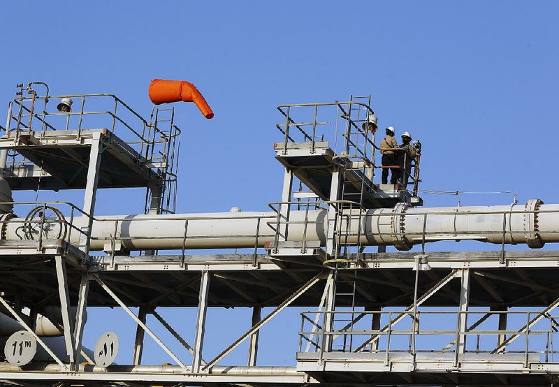 Workers are shown in September at an Aramco oil processing facility in Abqaiq, Saudi Arabia, days after an attack that knocked out about half of the kingdom’s daily production. 