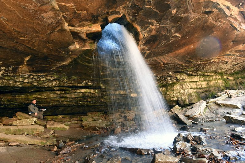 NWA Democrat-Gazette/FLIP PUTTHOFF Glory Hole waterfall pours through a hole in a rock shelf Nov. 8 2019 in the Ozark National Forest. It's a 1-mile hike from Arkansas 21 to the waterfall and a mile hike out for a 2-mile round-trip. Alan Bland of Rogers takes in the view of the unique cascade.