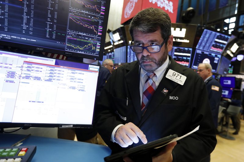 FILE- In this Dec. 5, 2019, file photo trader James MacGilvray works on the floor of the New York Stock Exchange. Stocks are opening mixed on Wall Street on Monday, Dec. 9, as investors weighed the possibility of more U.S. tariffs on China kicking in. (AP Photo/Richard Drew, File)