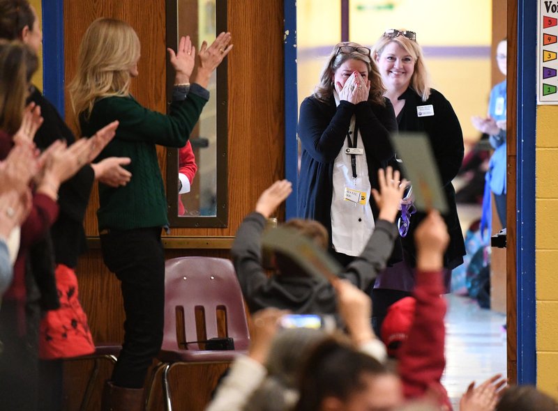 Kari Kinne, Leverett Elementary School assistant principal, reacts Tuesday after being surprised with a school assembly to announce she won Assistant Principal of the Year Award. Richard Abernathy, director for the Arkansas Association of Educational Administrators, was on hand to present the award as well as Fayetteville School Board members and administrators. NWA Democrat-Gazette/J.T. WAMPLER