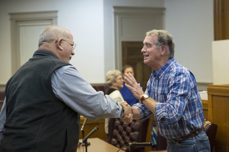 Columbia County Judge Larry Atkinson (right) shakes hands with Russell Thomas, District 3 justice of the peace, after the county CEO announced his early retirement Monday night. Atkinson’s last day in office will be Jan. 31, 2020.                                               
