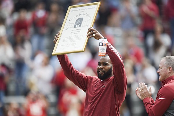 Former Arkansas running back Darren McFadden holds up a plaque commemorating his election to the College Football Hall of Fame during a football game between the Razorbacks and Auburn on Saturday, Oct. 19, 2019, in Fayetteville. 