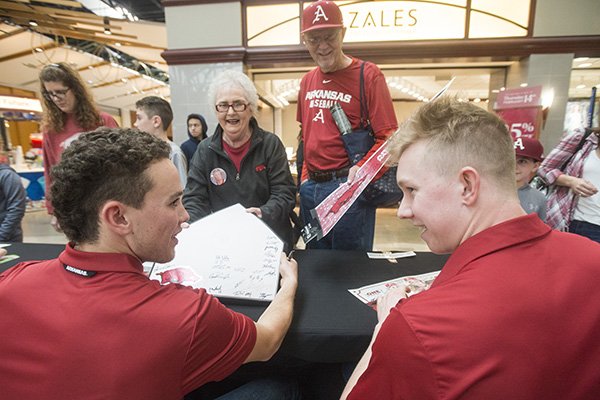 Pamela Short and husband David Short of Grapevine, Texas, (grandparents of Arkansas pitcher Kole Ramage), get autographs from infielder Coby Boulware (left) and outfieder Heston Kjerstad Saturday, Feb. 9, 2019, during Arkansas baseball's annual Meet the Razorbacks Day at Northwest Arkansas Mall in Fayetteville.