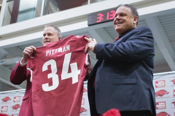 Arkansas football coach Sam Pittman (right) and athletics director Hunter Yurachek pose for pictures, Monday, Dec. 9, 2019 during Pittman's introductory news conference in Fayetteville.
