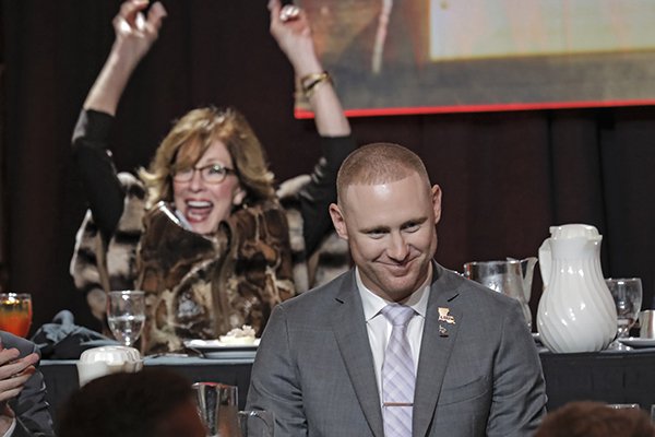LSU passing game coordinator Joe Brady smiles after winning the 2019 Broyles Award on Tuesday, Dec. 10, 2019, in Little Rock. In the background Carole Smith reacts as his name is announced. Smith hosted Brady and his girlfriend during their state in Little Rock. The Broyles Award is given to the top college assistant coach in the country. 