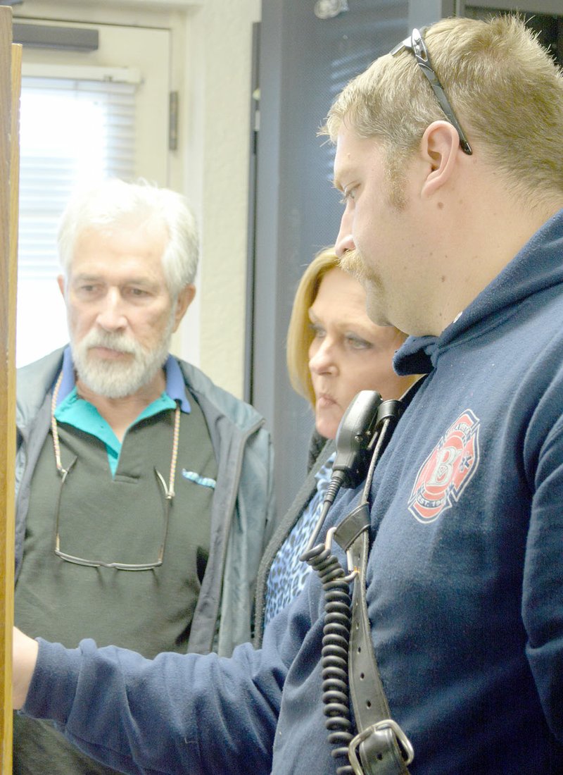 Keith Bryant/The Weekly Vista Citizens Helping Improve Public Safety co-chairs Dan Jeffrey (left) and Billie Hall examine a map as Bella Vista firefighter Justin Stanbery explains which portions of the city each fire station covers.