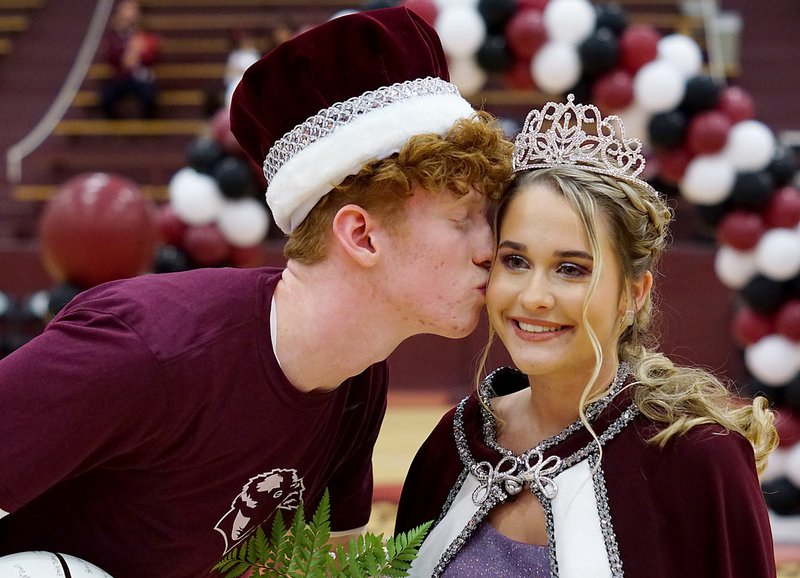 Westside Eagle Observer/RANDY MOLL Gentry senior Casey Bates kisses Meledy Owens on the cheek at the Gentry Basketball coronation ceremonies at Gentry High School on Friday night. Bates was revealed as captian and Owens as coronation queen during the ceremonies.