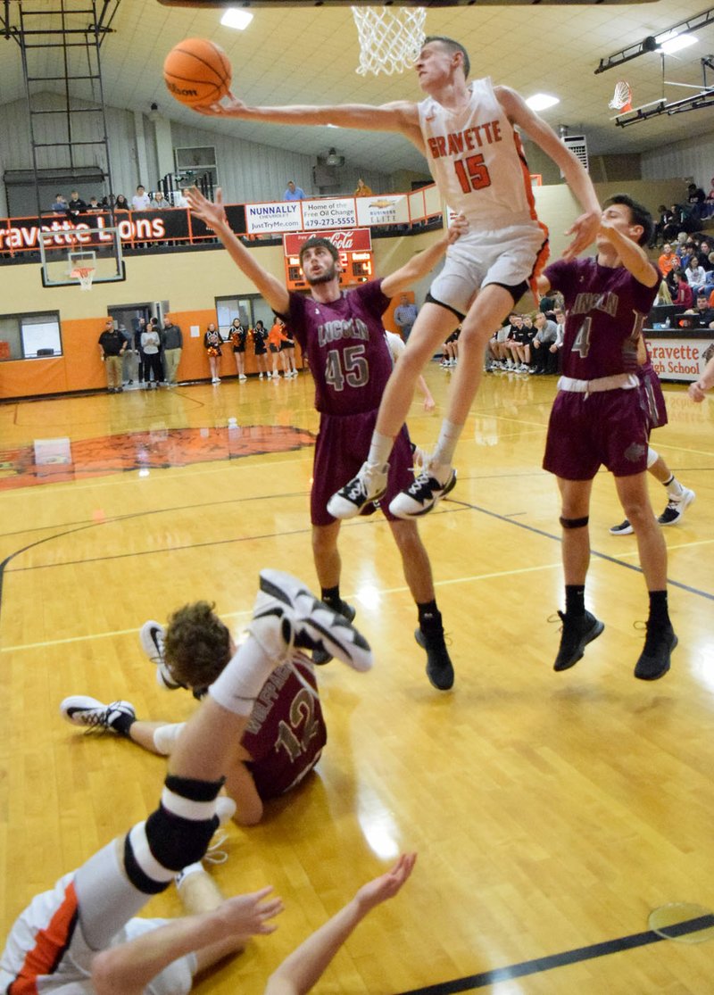 Westside Eagle Observer/MIKE ECKELS Gravette's Kaleb Furlow (No. 15) snatches a Lions' rebound away from Lincoln's Cole Criscom (No. 45) during the first quarter of the Gravette-Lincoln varsity basketball game at the Competition Gym Dec. 3. Gravette took a nonconference 61-41 win in boys basketball.