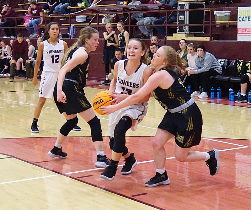 Westside Eagle Observer/RANDY MOLL Gentry senior Ariel Nix attempts to move the ball past West Fork defenders during play at Gentry High School on Dec. 3.
