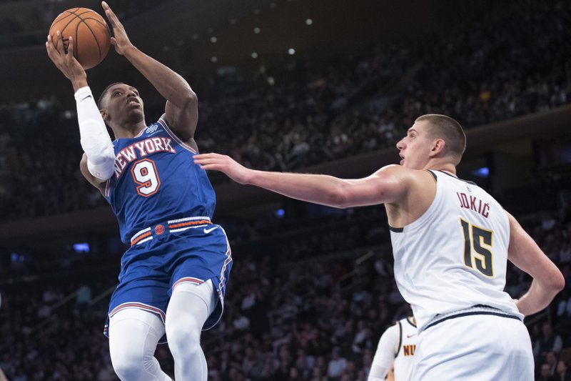 New York Knicks forward RJ Barrett (9) shoots next to Denver Nuggets center Nikola Jokic (15) during the second half of an NBA basketball game Thursday, Dec. 5, 2019, at Madison Square Garden in New York. (AP Photo/Mary Altaffer)