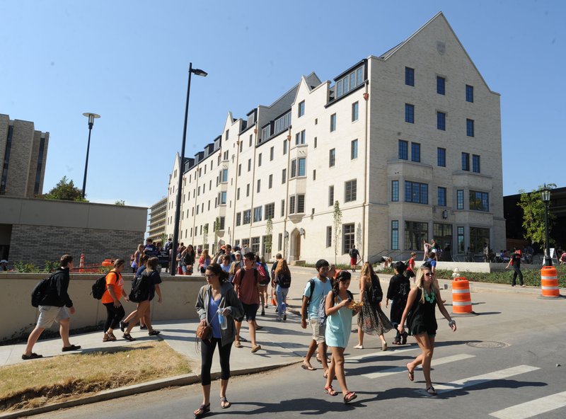 In this 2013 file photo, students cross Dickson Street on the University of Arkansas campus in Fayetteville prior to a dedication ceremony for the newly completed Founders Hall.