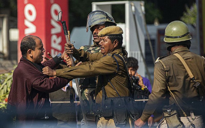 A protester scuffles with police officers Wednesday in Gauhati, India, at a demonstration over the new citizenship bill that excludes Muslims. More photos available at arkansasonline.com/1212bill/.
(AP/Anupam Nath) 