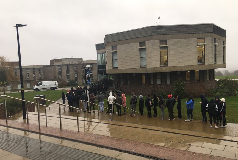 In this photo made available by Jack Dice, people queue up to cast their ballots in the general election, at the University of Kent, in Kent, England, Thursday, Dec. 12, 2019. Britain is holding an early election in wintry December, with a number of strange locations put in use as polling places. Among the places where Britons cast their ballots Tuesday were a car dealership, a laundrette, a Christmas grotto and of course some pubs. There were a few problems, including flooding at one location. (Jack Dice via AP)

