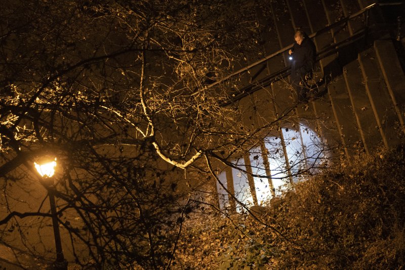 A New York City police department detective use a flashlight to look for evidence in Morningside Park, Thursday, Dec. 12, 2019, in the Upper West Side of Manhattan. Tessa Majors, a 18-year-old Barnard College freshman from Virginia, was fatally stabbed in the park near the school's campus in New York City. (AP Photo/Mary Altaffer)