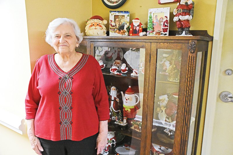 Wanda Emde of Searcy stands in front of a curio cabinet with some of her 1,658 Santas that she’s collected since 1964. More than 600 of her Santas are on display for the public at Carmichael Community Center, 801 S. Elm St. Emde helps unpack and display the Santas, even though she started losing her vision 20 years ago.