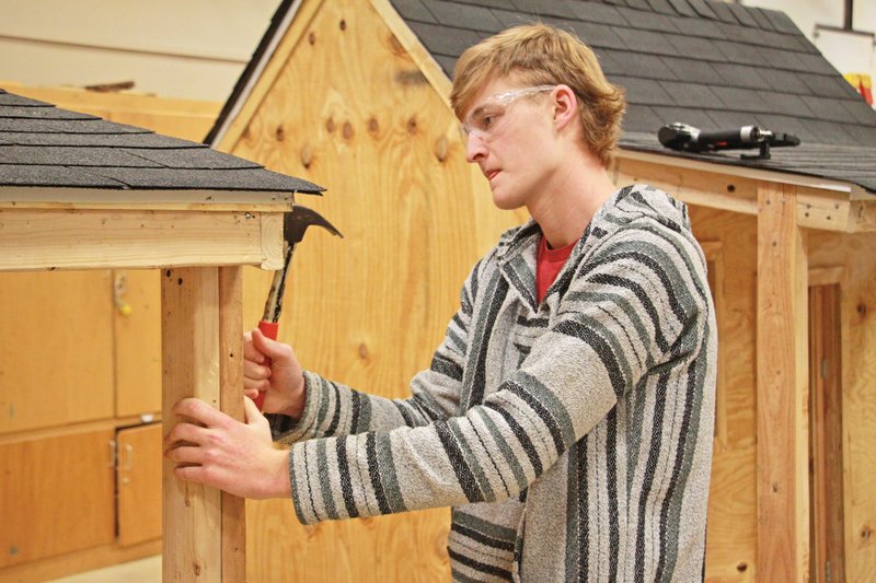 Benton High School senior Grant Steed works on one of the playhouses in the shop at the school. The class is selling the playhouses to raise money for supplies for the classroom.