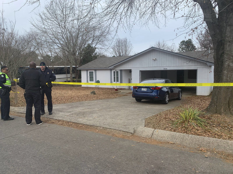 Police stand at the scene of a homicide at 5416 Brush Creek Ave. in Little Rock on Saturday. 