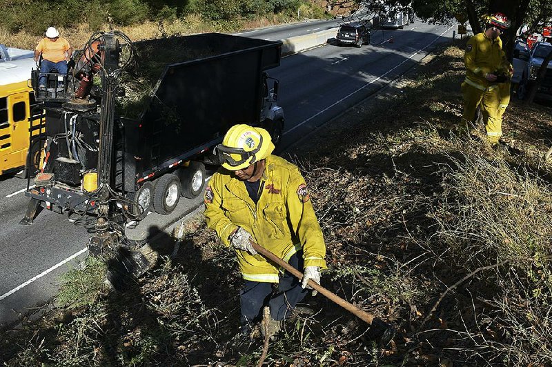 A fire prevention crew removes vegetation along California’s Route 17 in November near Redwood Estates, Calif.  